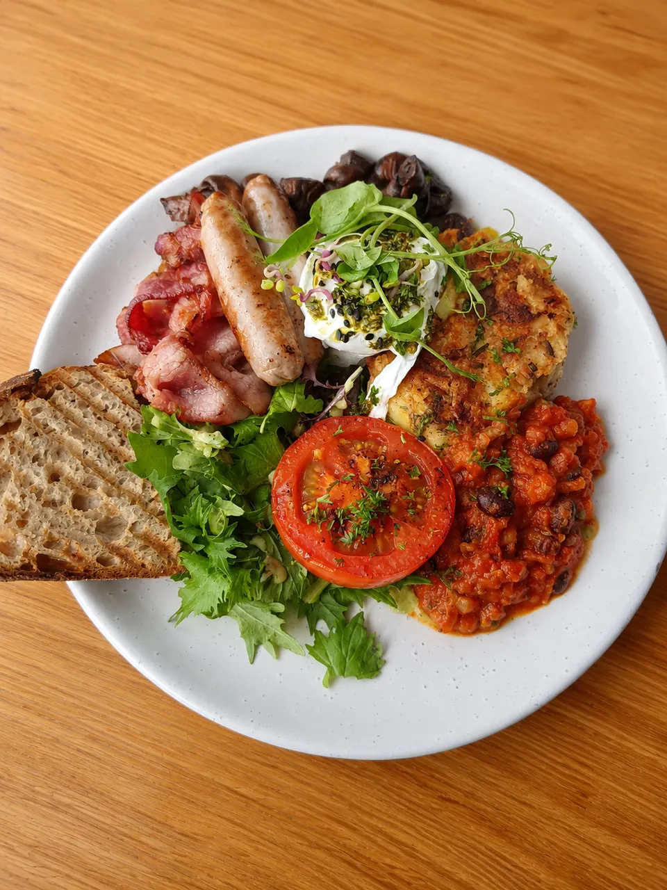A cooked breakfast with eggs, bacon, sausage, beans and toast at Suburban Rascal